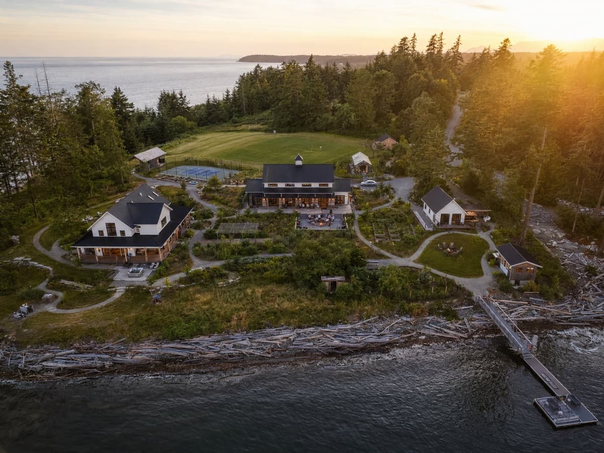 Coastal farmstead compound with white farmhouses, gardens, and a private dock